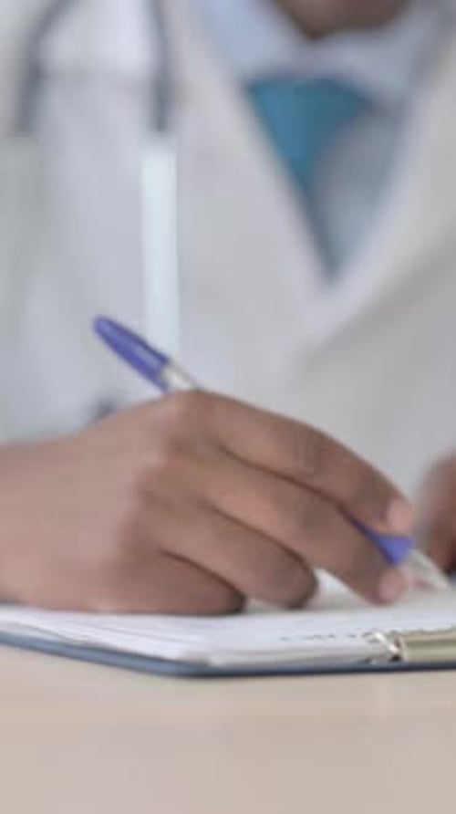 Médecin africain travaillant sur des documents médicaux, Vidéo verticale