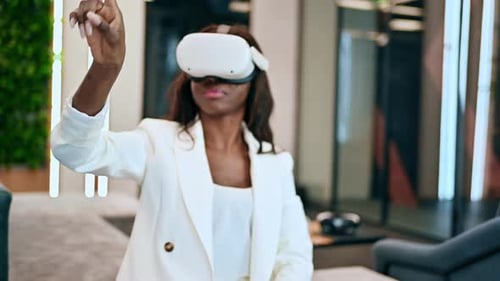 A black woman exploring virtual reality using VR glasses in an office