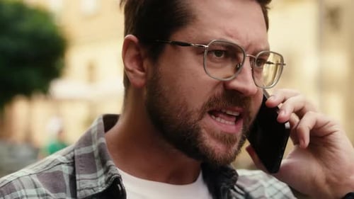 Angry Man Talking on Phone Outside