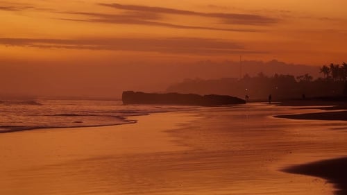 Tropical Beach at Golden Sunset with Silhouetted Figures