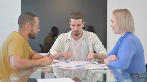 Colleagues Collaborating Over Business Reports in Office
