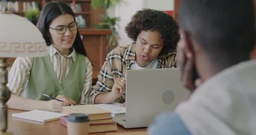 Group of Students Working at Project Together Using Laptop and Talking Brainstorming in University