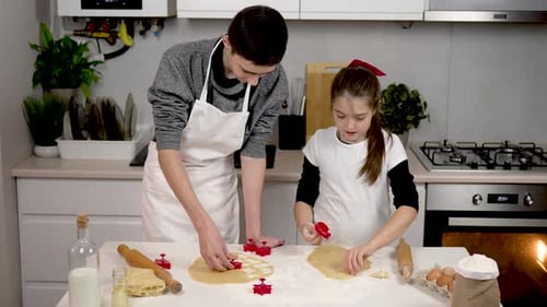 Happy Brother and Sister Wearing Apron Cutting Dough with Cookie Cutter in Cozy Kitchen Children