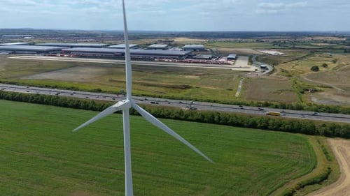 Aerial view of wind turbine, highway and factory , United Kingdom.