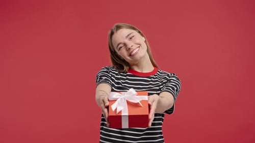 Smiling Woman Offers a Birthday Gift Box