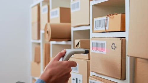 Hand Holds The Scanner Scans The Barcode On The Boxes The Warehouse Of The Parcels Of Boxes