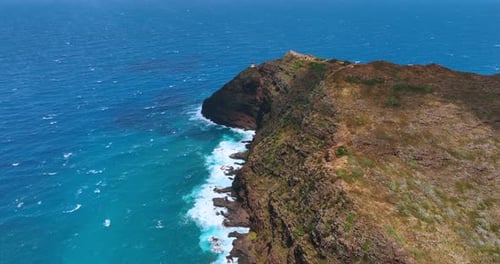 Huge bare mountain with no vegetation at the coast of the ocean.