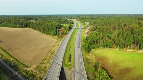 4K Forward moving aerial view of 4-lane highway with cars and trucks passing both directions during
