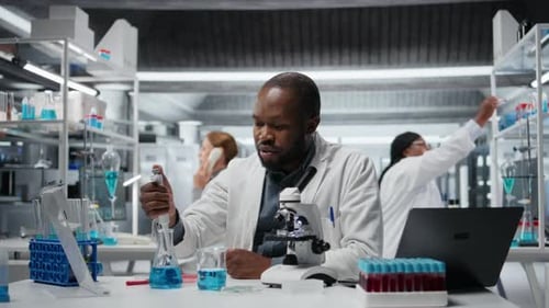 Un expert en développement d'essais pipetant un réactif dans une solution pour l'analyse de la pureté