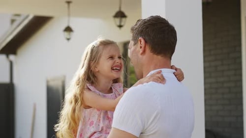 Loving Father and Daughter Hug Outside their Home
