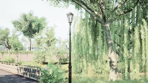 Serene Park Pathway with a Lamp Post and Lush Greenery in a Sunny Afternoon