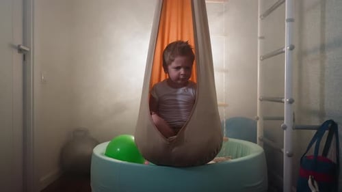 Cute Blond Toddler Frowns Moving Head to Sides in Home Gym