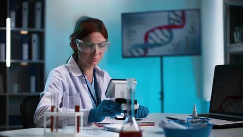 Woman Scientist Works with Microscope in Lab