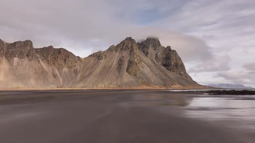Drone push-in towards Vestrahorn horny mountains in Stokksnes, Iceland - epic volcanic landscape
