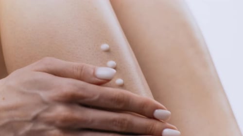 Arm Spreads Cream on Leg for Moisturizing