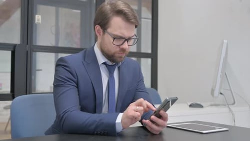 Adult Man Uses Mobile Phone in Office