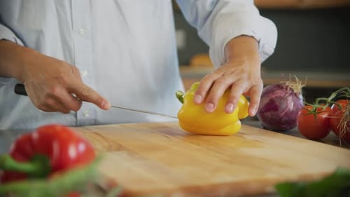 Close Up of Man Cutting Yellow Bell Pepper