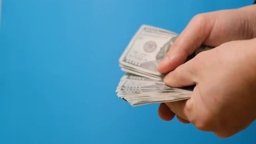 Hands Counting Stack of United States Dollars