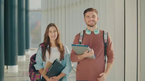 Portrait of Two Attractive Students with Books at High School College Hall