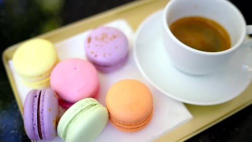 Macarons français colorés avec une tasse de café noir