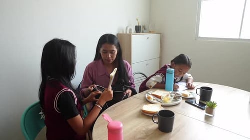 Young Asian Mother Helps Her Teenage Daughter Prepare To Go To School