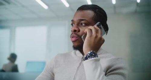 Young Adult on Phone in Bright Office