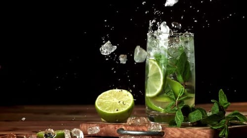 Eis fällt in einen Mojito-Cocktail, der mit einer Hochgeschwindigkeitskamera mit 1000 Bildern pro Sekunde gefilmt wurde