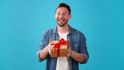 Man Holding Wrapped Birthday Gift with Red Ribbon