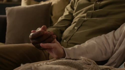 Romantic Couple Holding Hands on Couch at Home