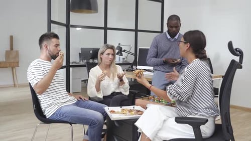 Multiracial Coworkers Eating Pizza in the Office