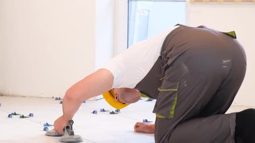 Installer Placing Floor Tile with Suction Tool
