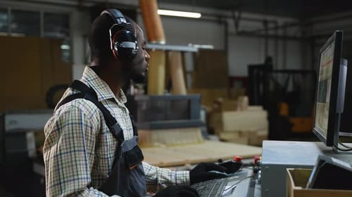 African American CNC Operator Programs Wood Cutting Machine