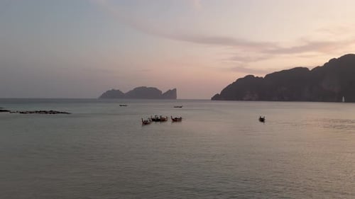 Drone aerial view of longtail boats at sunset in Koh Phi Phi, Thailand