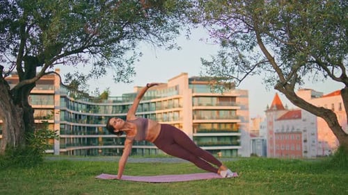 Woman Practicing Yoga Outdoors in City Park