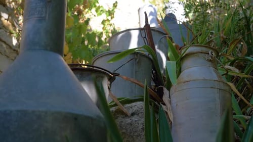 Metal Buckets On The Steps Of A Provencal Village in slowmotion in summer with milk bucket vintage.