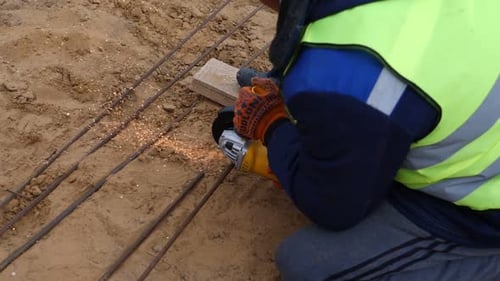 Construction Worker Cutting Rebar With Metal Grinder