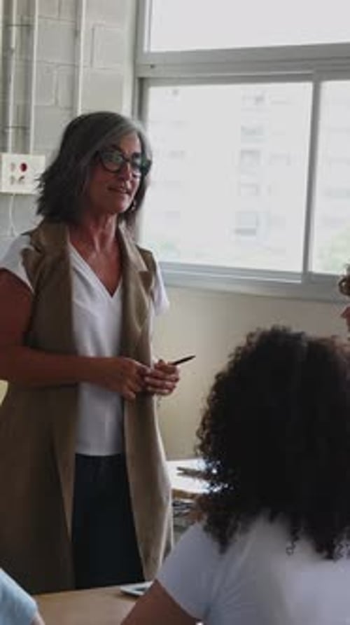 Experienced Teacher Giving Lesson to Diverse High School Students