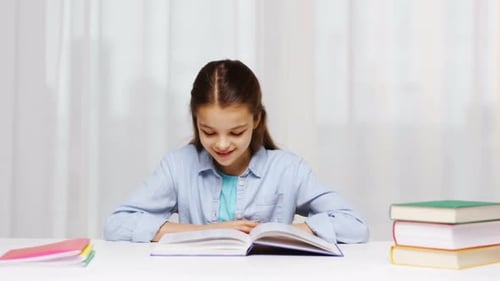 Education People Children and Learning Concept - Happy School Girl Reading Book