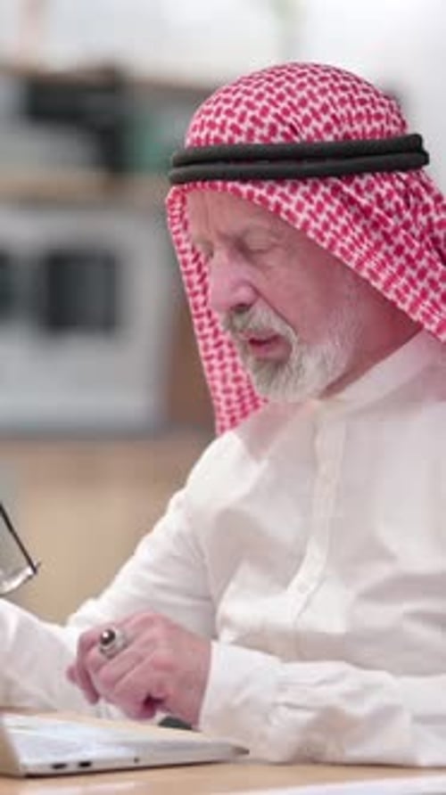 Senior Man Wearing Keffiyeh Working on Laptop