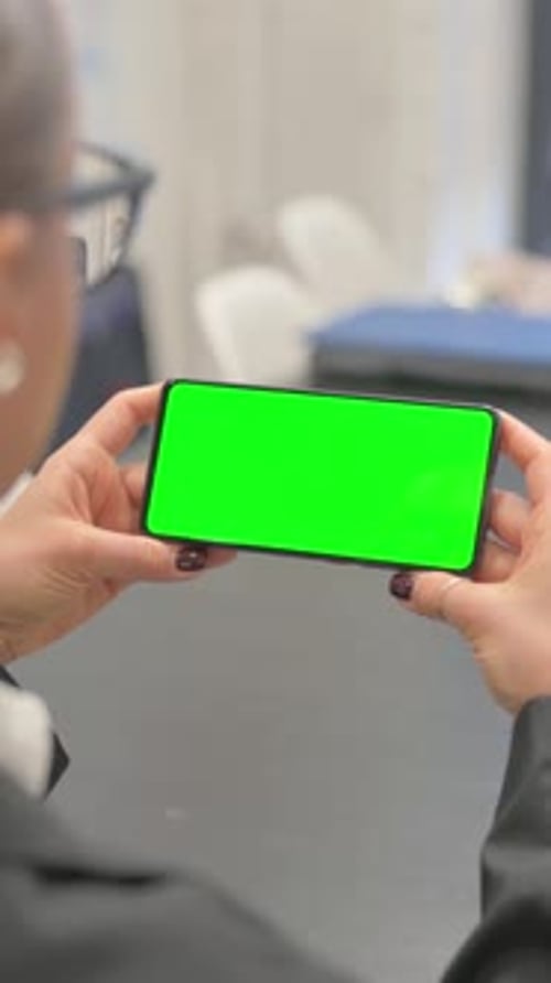 Business Woman Holding Horizontal Green Screen Smartphone, vertical video