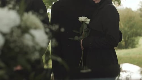 Woman Holding Roses at Funeral