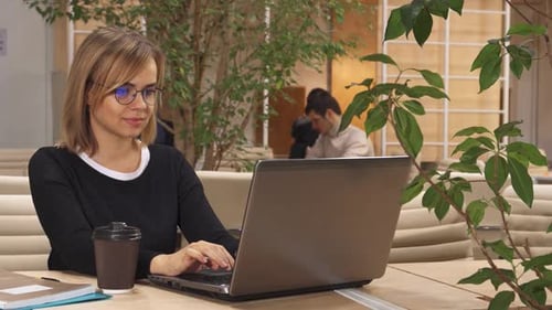 Fille concentrée travaillant sur un ordinateur portable dans un centre de coworking moderne