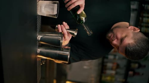 Bartender Making Cocktail with Bottle and Jigger