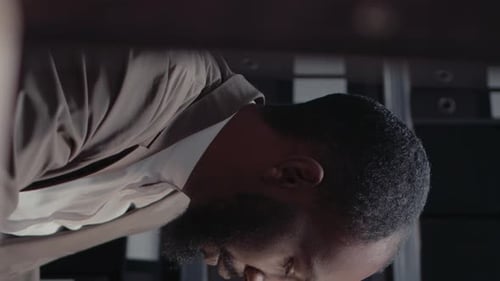 Man Leans Over Desk in Office Close Up