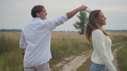 Couple Holding Hands Walks Down a Rural Path