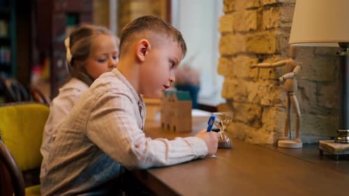Children Drawing Together Indoors at Wooden Table