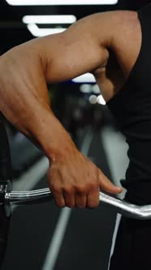 Closeup Video Frames Show an Intense Arm Workout in a Modern Gym Featuring a Muscular Bicep and