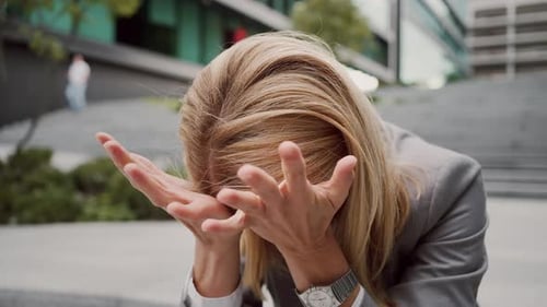 Frau sitzt voller Angst auf der Treppe des Geschäftszentrums