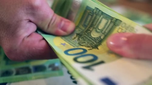 Close-up two people can not share the money pull each other pack of 100 euro bills.