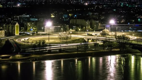 Timelapse Of Traffic Driving In The City At Night With Light Reflection Of The River.